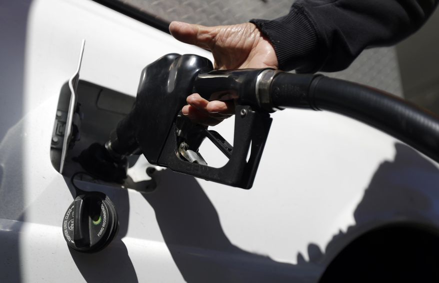 FILE - In this Wednesday, Oct. 26, 2016, file photo, an attendant at a Shell gas station pumps gas for a motorist in Hasbrouck Heights, N.J. Energy companies and banks led the rally on the S&P 500 in 2016. (AP Photo/Julio Cortez, File)