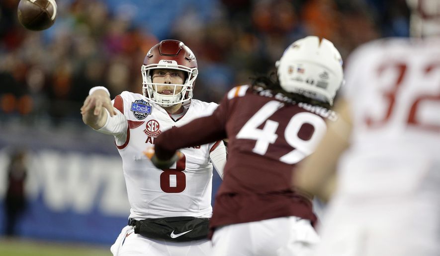 Arkansas&#39;s Austin Allen (8) fires a pass off to teammate, Hayden Johnson (32), as Virginia Tech&#39;s Tremaine Edmunds (49) defends during the first half of the Belk Bowl NCAA college football game in Charlotte, N.C., Thursday, Dec. 29, 2016. (AP Photo/Bob Leverone)