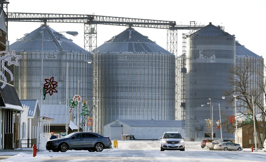 Traffic is seen on main street in front of the local grain elevator, Tuesday, Dec. 13, 2016, in Renwick, Iowa. Once-bustling Renwick has lost many businesses as its population declined, but when the town's sole bar closed this year, a group of friends pooled their money to repair and reopen the place as the Blue Moose Saloon. They said without a meeting place, Renwick wouldn't be much of a town. (AP Photo/Charlie Neibergall)