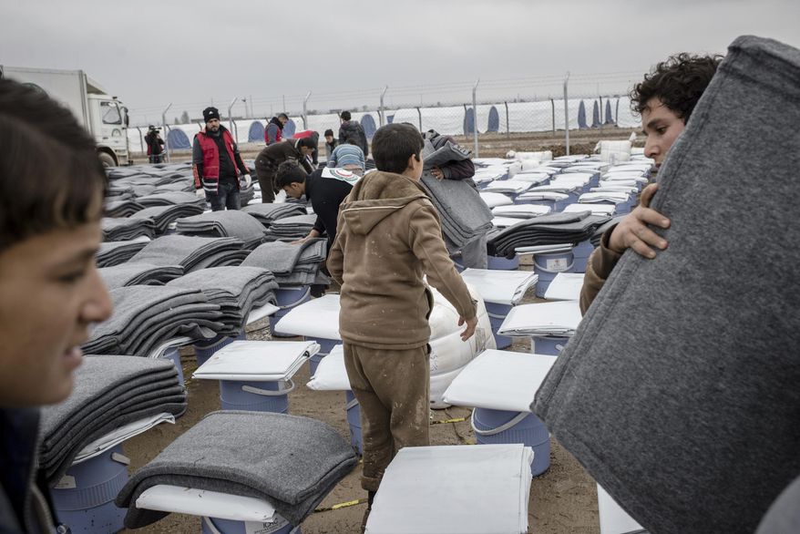 Iraqis displaced from Mosul receive aid distributions at near Qayara, Iraq on Wednesday, Dec. 28, 2016. (AP Photo/Cengiz Yar)