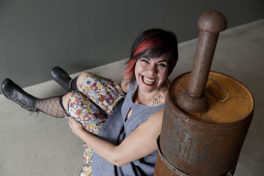 Amber Clisura poses for a picture next to the meat smoker she donated to the new Museum of Broken Relationships Wednesday, Dec. 28, 2016, in Los Angeles. The Museum of Broken Relationships displays artifacts from failed unions, most of them mundane under ordinary circumstances. (AP Photo/Chris Carlson)