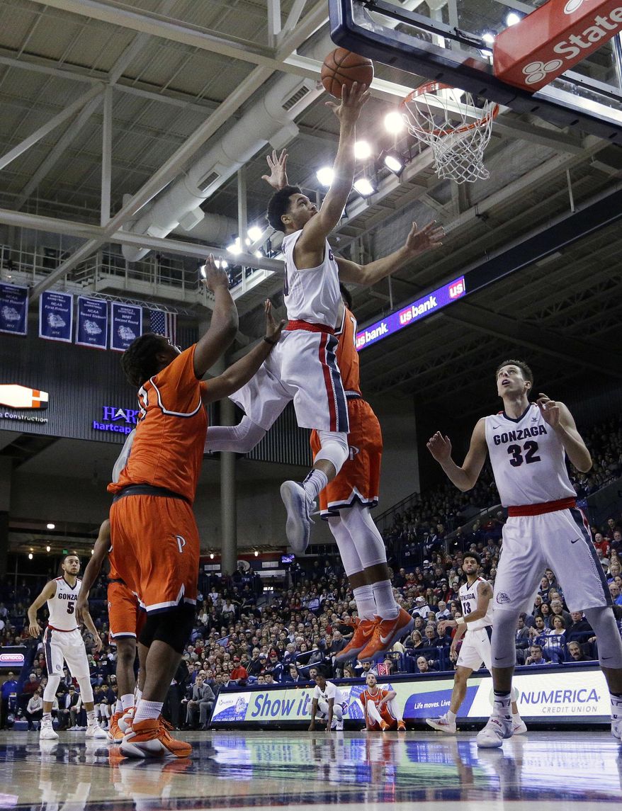 Gonzaga guard Silas Melson, center, shoots while defended by Pepperdine forward Nolan Taylor, left, and forward Chris Reyes during the first half of an NCAA college basketball game in Spokane, Wash., Thursday, Dec. 29, 2016. (AP Photo/Young Kwak)