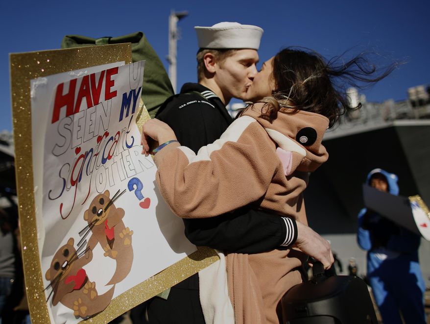 In costume and carrying a sign reading "Have u seen my significant otter?" Melanie Till welcomes her husband, P.O. 3rd Class David Till, home after the USS Dwight D. Eisenhower returned to Naval Station Norfolk, in Norfolk, Va., on Friday, Dec, 30, 2016, from a seven-month deployment to the Middle East and the Mediterranean Sea. (Stephen M. Katz/The Virginian-Pilot via AP)