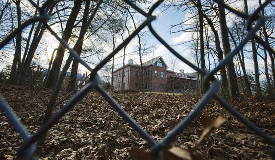 A fence encloses an estate in the village of Upper Brookville in the town of Oyster Bay, N.Y., on Long Island on Friday, Dec. 30, 2016. (AP Photo/Alexander F. Yuan)