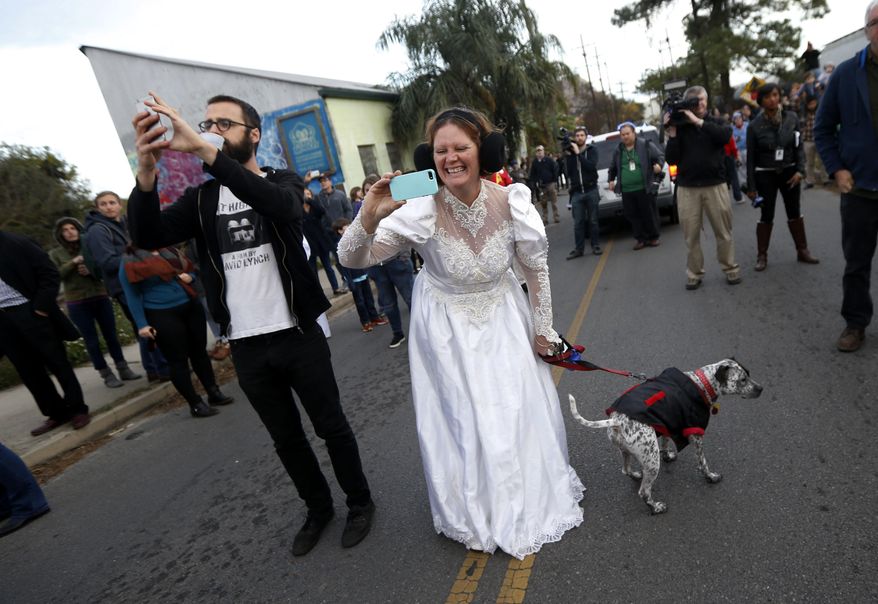 Beckie Wasden, dressed as Princess Leia, takes a photo during a parade in honor of actress Carrie Fisher, who played Princess Leia in the "Star Wars" movie series, in New Orleans, Friday, Dec. 30, 2016. Fisher died on Dec. 27, 2016, at the age of 60. The parade was held by the Krewe of Chewbacchus, a "Star Wars" themed Mardi Gras Krewe. (AP Photo/Gerald Herbert)