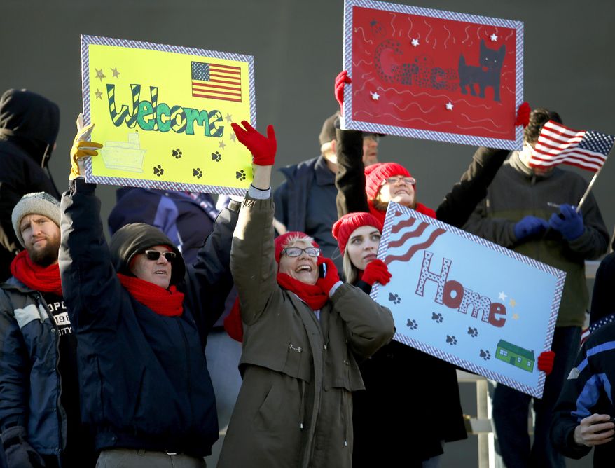 Family and friends wave to their sailors as the USS Dwight D. Eisenhower returned to Naval Station Norfolk, in Norfolk, Va., on Friday, Dec. 30, 2016, after a seven-month deployment to the Middle East and the Mediterranean Sea. (Stephen M. Katz/The Virginian-Pilot via AP)