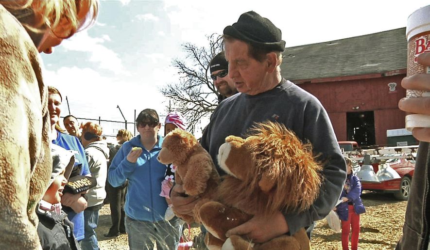 FILE – In this April 4, 2015, file photo, Kenny Hetrick, owner of Tiger Ridge Exotics, holds stuffed toy animals as he speaks to visitors at an Easter egg hunt fundraiser in Stony Ridge, Ohio. Hetrick, who is fighting the state for the return of his tigers and other exotic animals, will be allowed to see some of the animals. A state appeals court said the owner and his veterinarian will be allowed to examine the animals that were sent to a South Dakota sanctuary and later removed from there because of neglect. (AP Photo/Mike Householder, File)