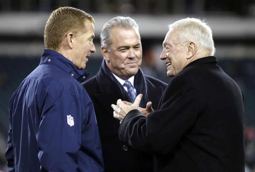 FILE - In this Dec. 14, 2014, file photo, Dallas Cowboys owner Jerry Jones, right, and son Stephen Jones talk with head coach Jason Garrett before an NFL football game against the Philadelphia Eagles in Philadelphia. Cowboys owner Jerry Jones stuck with Garrett despite one playoff berth and winning record in his first five full seasons and now his team is the top seed in the NFC. (AP Photo/Matt Rourke, File)