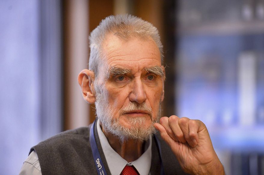 In this Dec. 6, 2016, photo, University of Utah physician John Opitz poses for a photo at the university's Health Sciences Library in Salt Lake City. Opitz has received the Order of Merit of the Federal Republic of Germany for his work in medical genetics. (Trent Nelson/The Salt Lake Tribune via AP)