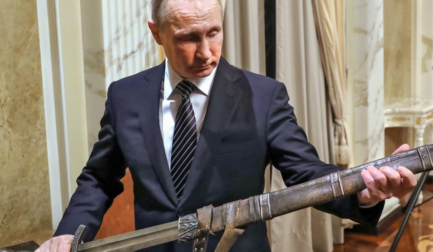 Russian President Vladimir Putin holds a sword while listening an explanations from the head of Russian First Channel Konstantin Ernst, during his meeting with the historical action film Viking&#x27;s crew, in Moscow, Russia, Friday, Dec. 30, 2016.  Viking is a historical action film based on the historical document Primary Chronicle and Icelandic Kings&#x27; sagas. (Mikhail Klimentyev, Sputnik, Kremlin Pool Photo via AP)