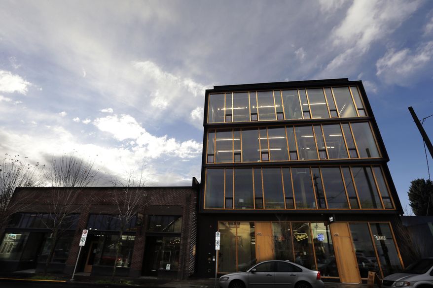 This Nov. 15, 2016, photo shows Lever Architecture headquarters, a four-story all-wood building built using cross-laminated timber, or CLT, in Portland, Ore. CLT is made up of 2-by-4 beams laid out in perpendicular layers that are then glued together to make giant panels. (AP Photo/Don Ryan)