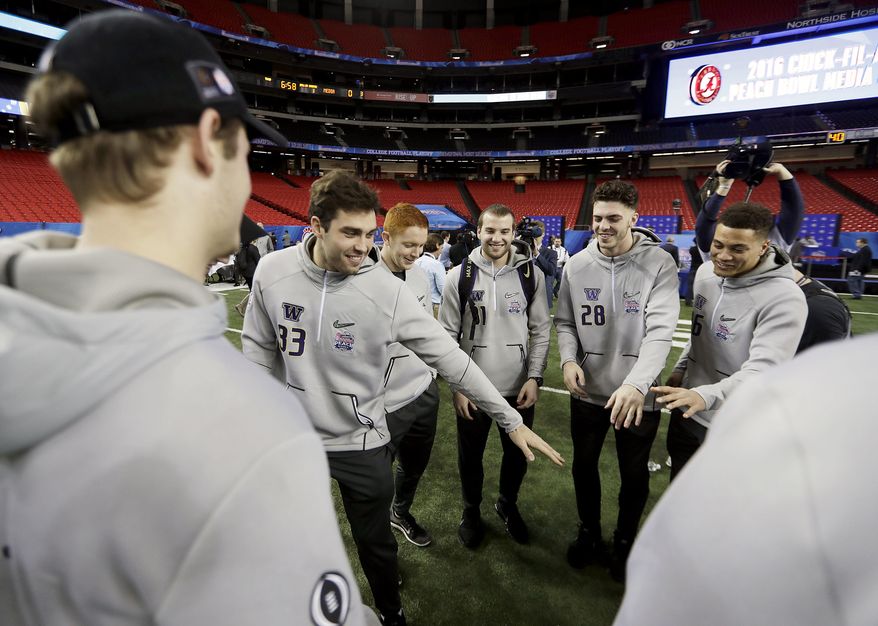 Washington's Connor Griffin, left, dances with teammates during media day for Saturday's Peach Bowl NCAA college football game against Alabama in Atlanta, Thursday, Dec. 29, 2016. (AP Photo/David Goldman)