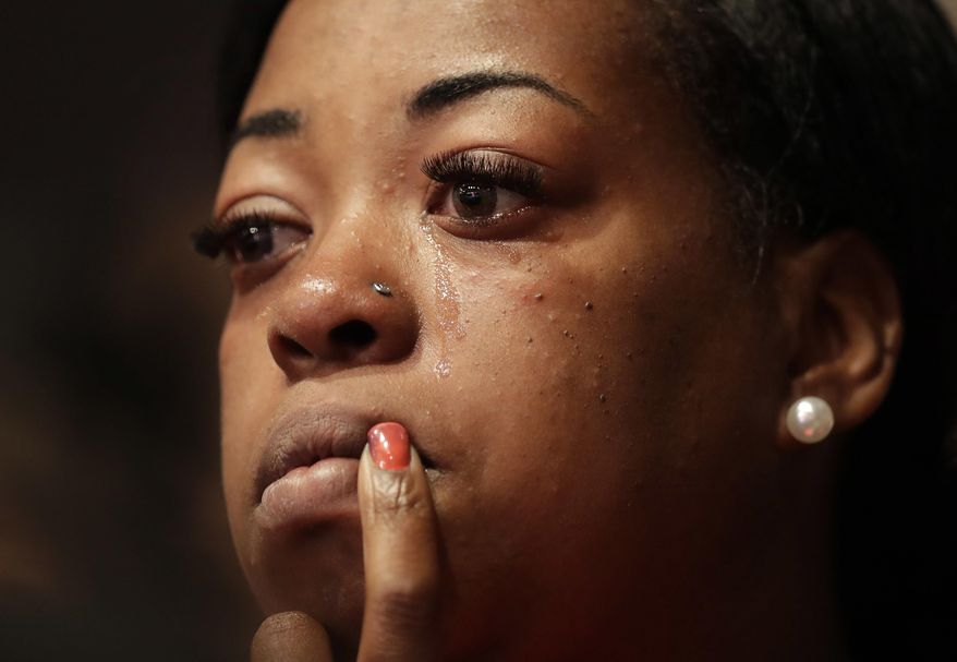 FILE - In this Sunday, July 10, 2016 file photo, a churchgoer cries during a service at the Potter's House in Dallas, that included a memorial to the five Dallas police officers killed the previous week as well as a town hall meeting discuss recent police shootings. A sniper killed the police officers during a protest over shootings of black men by police in Louisiana and Minnesota. (AP Photo/Eric Gay)