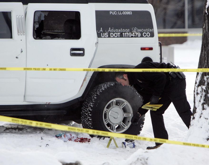 FILE - In this Jan. 1, 2007, file photo, an investigator with the Denver Police Department places evidence markers next to a Hummer limousine in which Denver Broncos cornerback Darrent Williams was shot and killed while riding inside, in Denver. It's been 10 years since 24-year-old Williams died in the early hours of New Year's Day after gunfire following a confrontation between Broncos players and gang members at a nightclub. His family is still trying to keep his memory alive.  (AP Photo/Ed Andrieski, File)