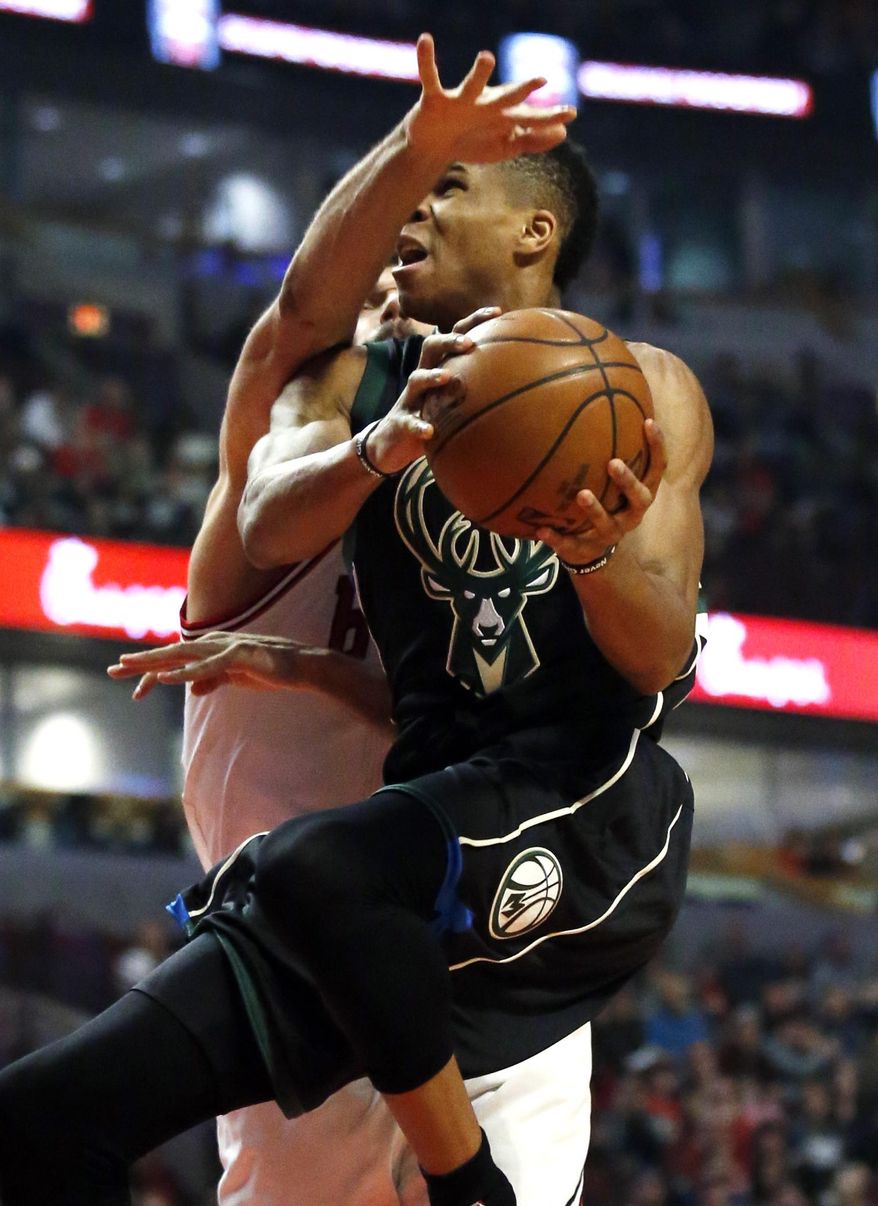 Milwaukee Bucks forward Giannis Antetokounmpo drives to the basket as Chicago Bulls center Robin Lopez defends during the first half of an NBA basketball game Saturday, Dec. 31, 2016, in Chicago. (AP Photo/Nam Y. Huh)