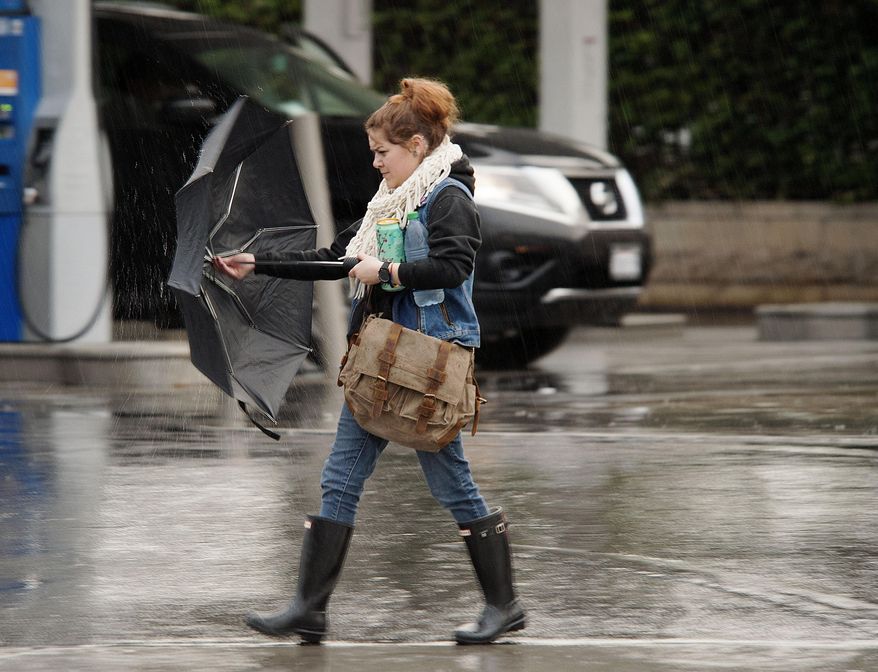 A woman puts her umbrella up as she prepares to cross St. N. College Blvd. as a light, warm rain falls Friday morning, Dec. 30, 2016 in Anaheim. California's wet December is drawing to a close with even more rain and snow in a welcome respite amid years of drought. A warm low-pressure storm system brought showers to Southern California starting early Friday and slowly moved east through the day as a cold weather system dropped down toward the state from the north. (Ken Steinhardt/The Orange County Register via AP)