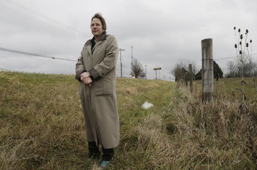 In this Dec. 12, 2016 photo, author Ann DAngelo stands in a ditch off of Highway 146 where parts of her book "Dark Highway" took place outside of New Castle, Ky. DAngelo's book describes the events surrounding the Nov. 6, 1936 murder of Vera Garr Taylor. (Pablo Alcala/Lexington Herald-Leader via AP)