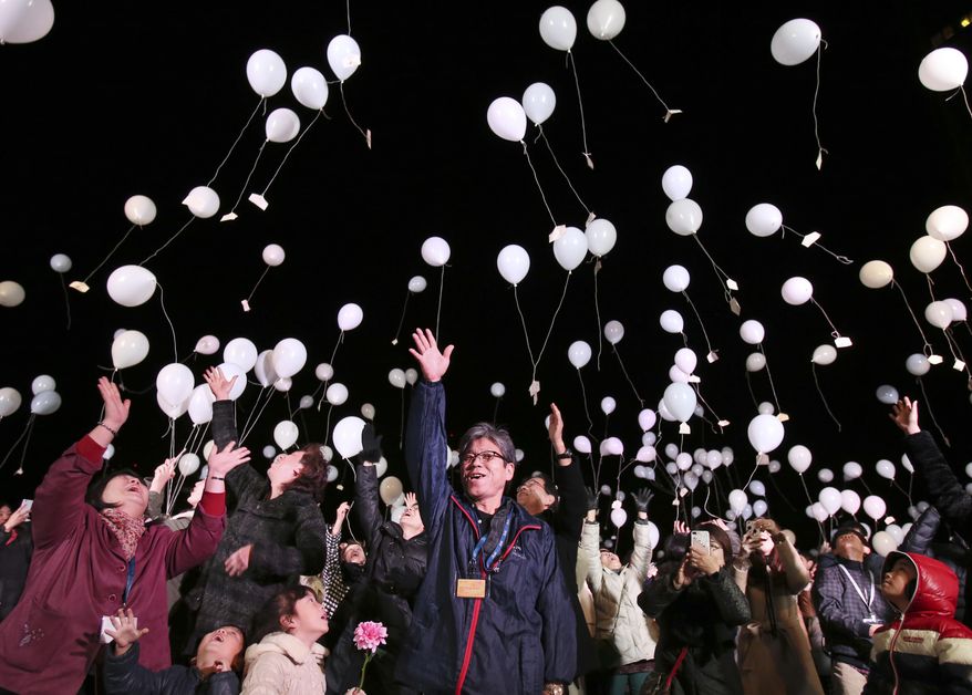 People release balloons into the air to celebrate New Year, during a New Year celebration event at a Tokyo Hotel, early Sunday, Jan. 1, 2017. (AP Photo/Koji Sasahara)