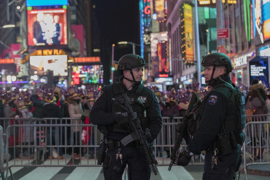 Police officers stand guard as revelers take part in a New Year's Eve celebration in New York's Times Square, Saturday, Dec. 31, 2016. (AP Photo/Mary Altaffer)