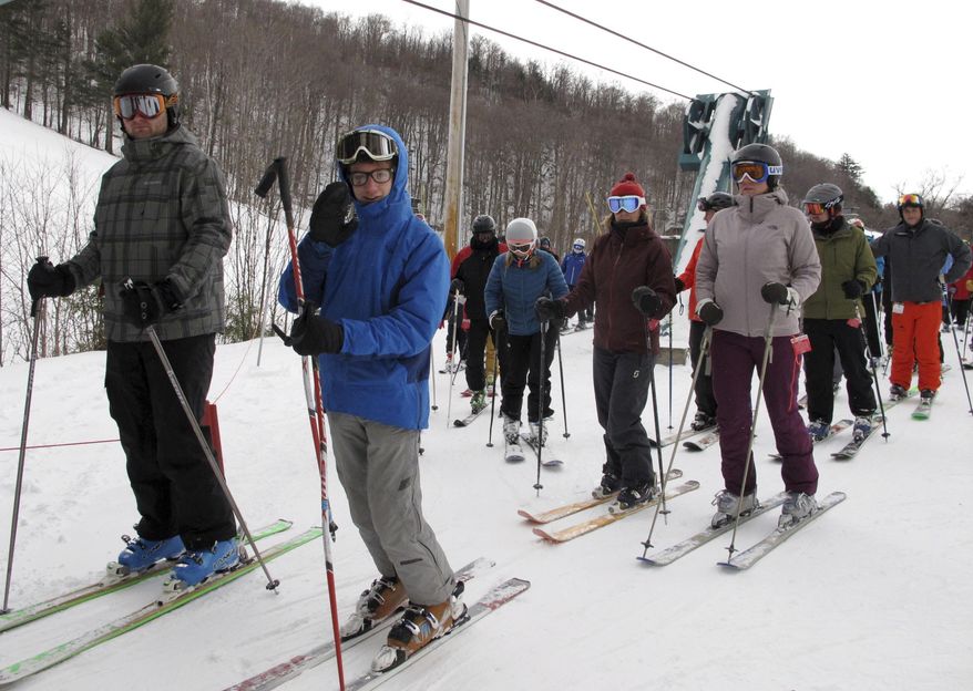 In this Dec. 30, 2016 photo, skiers stand in a lift line at Mad River Glen in Fayston, Vt. Northeast ski areas are relishing the new snow from a nor'easter that dumped as much as 20 inches in Maine, following a dismal season last winter with little natural snow. (AP Photo/Lisa Rathke)