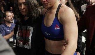 Ronda Rousey leaves the octagon after losing to Amanda Nunes in the first round of their women&#39;s bantamweight championship mixed martial arts bout at UFC 207, Friday, Dec. 30, 2016, in Las Vegas. Nunes won the fight after it was stopped in the first round. (AP Photo/John Locher)