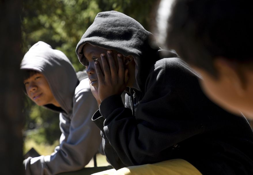 In this Sept. 10, 2016, photo, Gideon Muhigirwa, a 13-year-old refugee from Africa, center, listens during a photography lesson at Echo Lake near Idaho Springs, Colo. He belongs to Colorado Boy Scout Troop 1532, which is made up almost entirely of refugees. The troop's leaders say they try to teach the kids skills, even though maintaining youth membership makes it hard to focus on earning merit badges and rank advancement. (AP Photo/Thomas Peipert)
