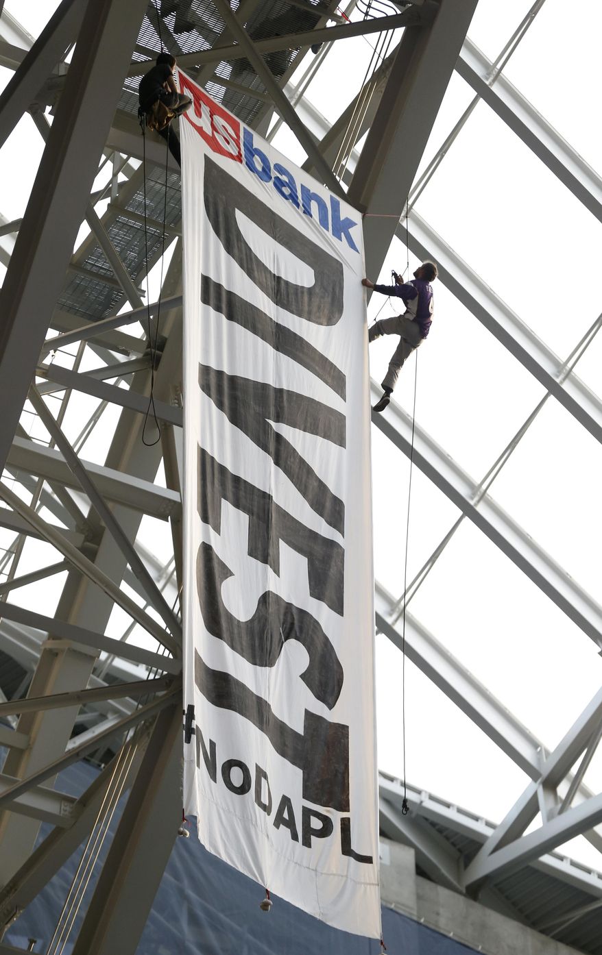 Protesters against the Dakota Access Pipeline rappel from the catwalk in U.S. Bank Stadium during the second half of an NFL football game between the Minnesota Vikings and the Chicago Bears on Sunday, Jan. 1, 2017, in Minneapolis. (AP Photo/Jim Mone)