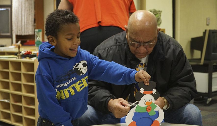 In this Tuesday, Dec. 20, 2016 photo, Mark Hernandez helps his grandson, Joseph Beourgeois decorate a snowman during a parent engagement breakfast at Lincoln Elementary School, in North Platte, Neb. Hernandez said he enjoys being able to spend the extra time with his grandson. (Kamie Stephens /The Telegraph via AP)