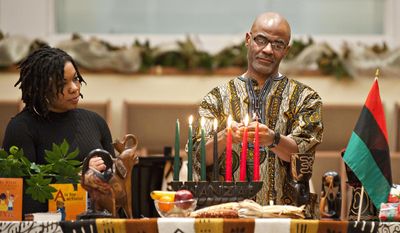 In this Tuesday, Dec. 27, 2016, file photo, Jessica Stunson, left, and Clay Smalley, both of Bowling Green, light the last two candles during the 16th annual Community Kwanzaa celebration at First Christian Church, in Bowling Green, Ky. (Miranda Pederson/Daily News via AP) ** FILE **