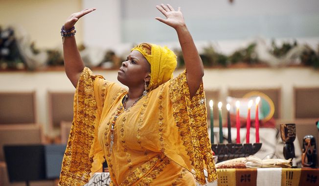 In this Tuesday, Dec. 27, 2016, Dr. Nubian Sun, of Bowling Green, performs a dance for the principle of Kuumba or creativity during the 16th annual Community Kwanzaa celebration at First Christian Church, in Bowling Green, Ky. (Miranda Pederson/Daily News via AP)