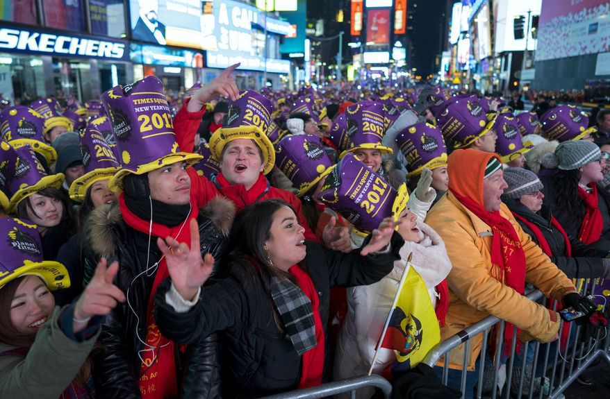 Revelers cheer for a musical act in New York's Times Square during New Year's Eve celebrations on Saturday, Dec. 31, 2016. (AP Photo/Craig Ruttle)