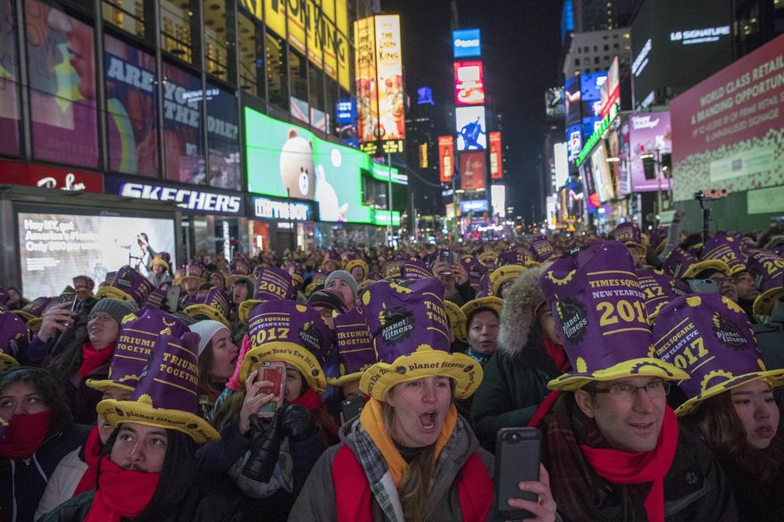 Revelers Alex, center, and Andy Groeger right, of Fort Collins Colo., take part in the New Year's Eve celebration in New York's Times Square, Saturday, Dec. 31, 2016. (AP Photo/Mary Altaffer)