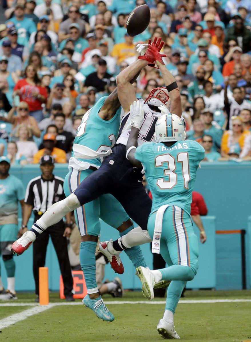 Miami Dolphins cornerback Bobby McCain (28) breaks up a pass intended for New England Patriots wide receiver Julian Edelman (11), during the first half of an NFL football game, Sunday, Jan. 1, 2017, in Miami Gardens, Fla. Miami Dolphins free safety Michael Thomas (31) defends. (AP Photo/Alan Diaz)