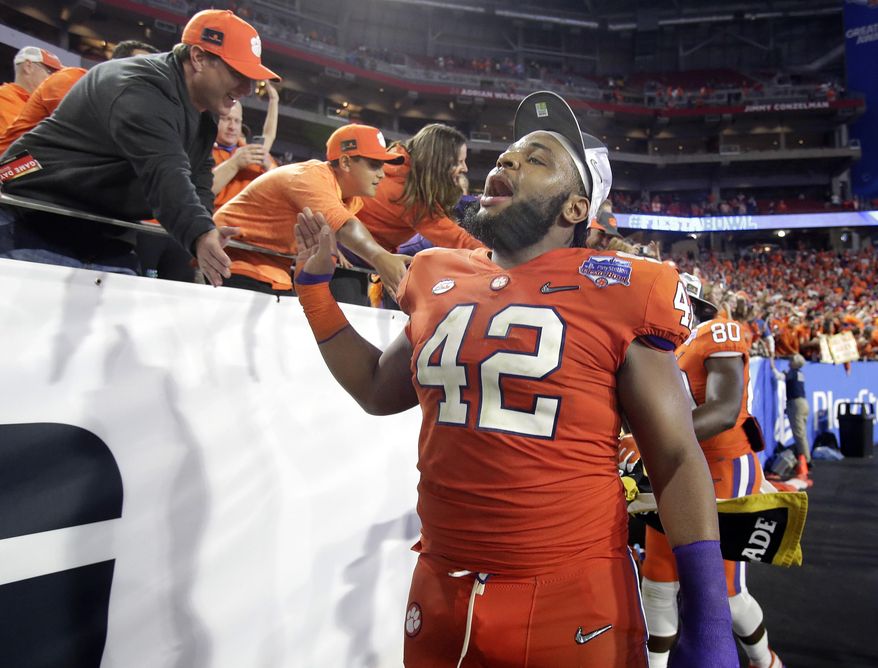 Clemson defensive lineman Christian Wilkins (42) greets fans after Clemson defeated Ohio State 31-0 in the Fiesta Bowl NCAA college football playoff semifinal, Saturday, Dec. 31, 2016, in Glendale, Ariz. Clemson advanced to the BCS championship game Jan. 9 against Alabama. (AP Photo/Rick Scuteri)