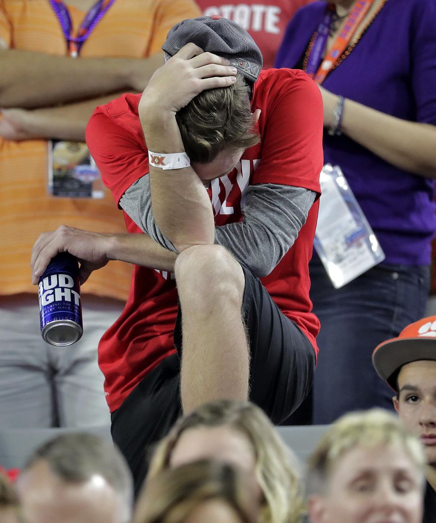 An Ohio State fan reacts during the second half of the team's Fiesta Bowl NCAA college football playoff semifinal against Clemson, Saturday, Dec. 31, 2016, in Glendale, Ariz. Clemson won 31-0 to advance to the BCS championship game against Alabama. (AP Photo/Rick Scuteri)