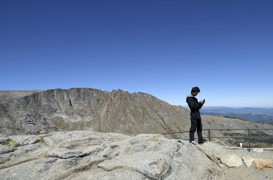 In this Sept. 10, 2016, photo, Bhim Adhikari, a 16-year-old Nepalese refugee, explores Mount Evans, near Idaho Springs, in Colorado's Rocky Mountains. He belongs to Boy Scout Troop 1532, which was formed in 2014 by Dr. P.J. Parmar in conjunction with a refugee clinic he runs in the Denver area. The troop is made up almost entirely of refugees. (AP Photo/Thomas Peipert)