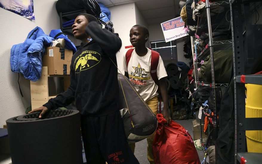 In this Sept. 9, 2016, photo, Boy Scouts Justin Mbelechi, left, and Gideon Muhigirwa, both 13 and refugees from Africa, gather gear in Aurora, Colo., before leaving on a troop camping trip to the mountains. Troop 1532 is made up almost entirely of refugees, a characteristic their leaders say allows the kids to adjust to American culture while allowing them to be themselves. (AP Photo/Thomas Peipert)