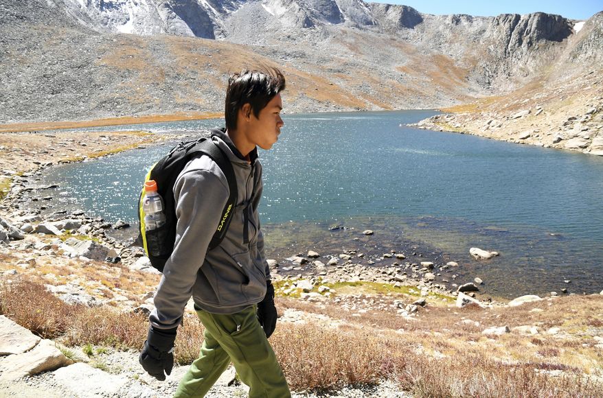 In this Sept. 10, 2016, photo, Micro Win, a 17-year-old refugee from Southeast Asia, hikes near the Summit of Mount Evans, near Idaho Springs, in Colorado's Rocky Mountains. The Boy Scout troop he belongs to, which caters to refugees, was formed in 2014 and helps kids adjust to American culture while providing an additional refuge. (AP Photo/Thomas Peipert)