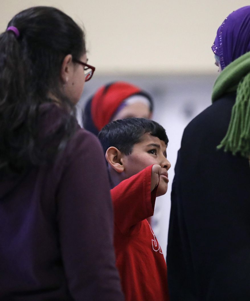 In this Dec. 10, 2016 photo, Syrian refugee Ahmad Alkhalaf talks with counselors during a day camp for local Muslim children in Sharon, Mass. The young boy who lost his arms in a refugee camp bomb blast is thriving in his new life in Massachusetts. (AP Photo/Charles Krupa)