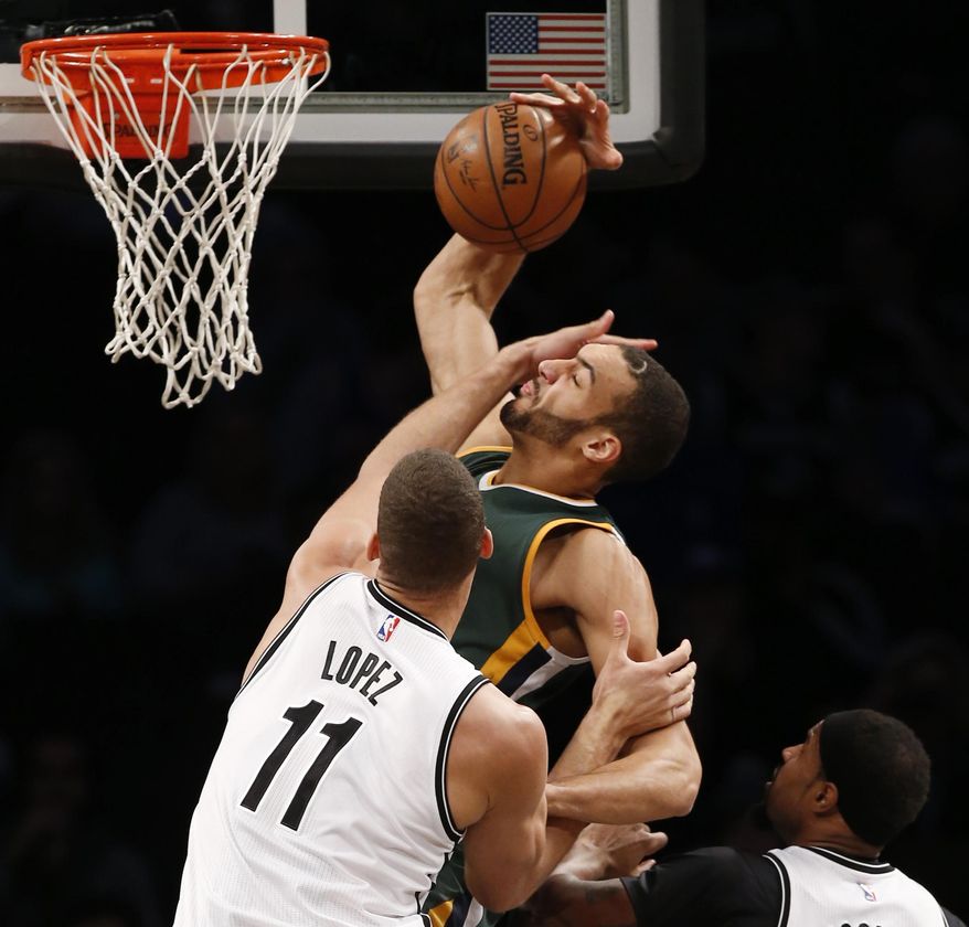 Brooklyn Nets' center Brook Lopez (11) interferes with a shot by Utah Jazz center Rudy Gobert in the first half of an NBA basketball game, Monday, Jan. 2, 2017, in New York. (AP Photo/Kathy Willens)
