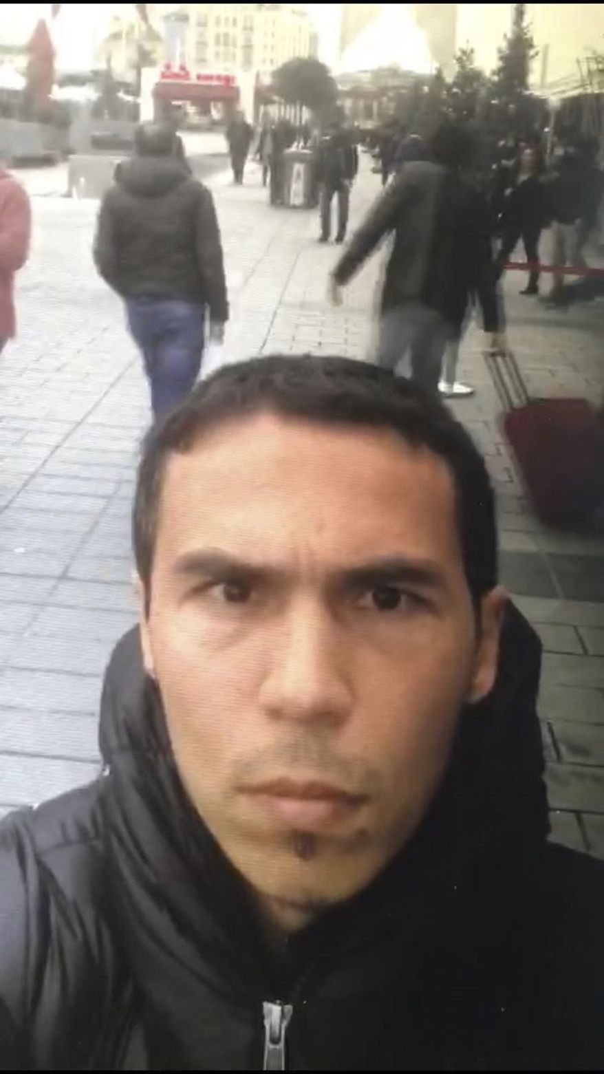 In this photo obtained Tuesday Jan. 3, 2017, in this undated photo a man believed to be the gunman who killed dozens at an Istanbul nightclub, films himself and the street behind him as he wanders nearby Istanbul's crowded Taksim square. An assailant armed with a long-barrelled weapon, opened fire at the nightclub in Istanbul's Ortakoy district during New Year's celebrations, killing dozens of people and wounding many others. No details have been released as to why the authorities might think the man in this selfie photo is a suspect in the New Years attack. (DHA-Depo Photos via AP)