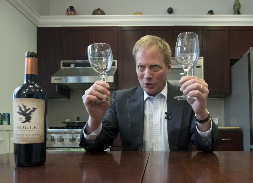 In this Tuesday, Dec. 6, 2016 photo, Brian Wansink, a food behavior scientist at Cornell University, holds wine glasses during a demonstration in a food lab at the university in Ithaca, N.Y. A study found that people poured 12 percent more wine when using a wide glass, 12 percent more when holding the glass, and 9 percent more when pouring white wine into a clear glass versus a colored or opaque one. Pour any glass only half full _ this cuts the average pour by 18 percent. (AP Photo/Mike Groll)