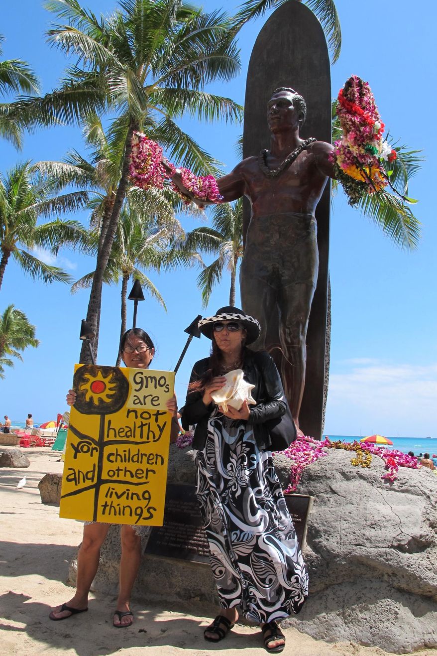 FILE - In this Saturday, May 23, 2015, file photo, Karen Murray, left, and Diane Marshall, both teachers from Honolulu, protest against Monsanto at a Waikiki Beach rally in Honolulu. Hawaii residents concerned about pesticides are planning a push to strengthen regulation over chemicals they fear harm their health. (AP Photo/Cathy Bussewitz, File)