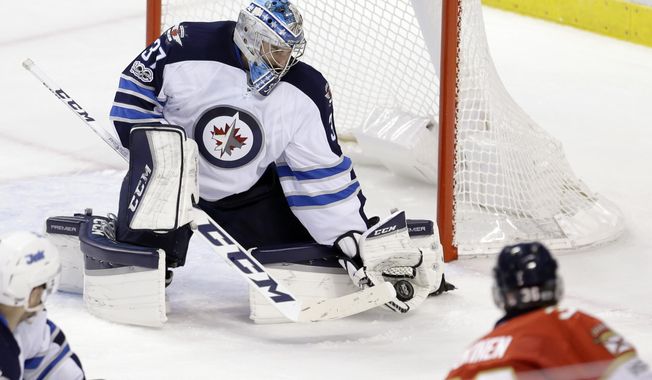 Winnipeg Jets goalie Connor Hellebuyck (37) blocks a shot by Florida Panthers left wing Jussi Jokinen (36) during the second period of an NHL hockey game, Wednesday, Jan. 4, 2017, in Sunrise, Fla. (AP Photo/Alan Diaz)