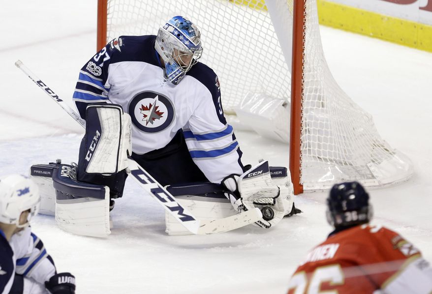 Winnipeg Jets goalie Connor Hellebuyck (37) blocks a shot by Florida Panthers left wing Jussi Jokinen (36) during the second period of an NHL hockey game, Wednesday, Jan. 4, 2017, in Sunrise, Fla. (AP Photo/Alan Diaz)