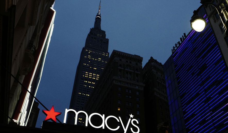 File- This Sept. 17, 2016, file photo shows a Macy's sign being illuminated on a store marquis, in New York. Macy's says it is eliminating more than 10,000 jobs and plans to move forward with 68 store closures after a disappointing holiday shopping season. The department store chain also lowered its full-year earnings forecast.(AP Photo/Mark Lennihan)