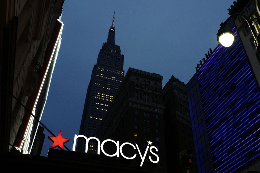 File- This Sept. 17, 2016, file photo shows a Macy's sign being illuminated on a store marquis, in New York. Macy's says it is eliminating more than 10,000 jobs and plans to move forward with 68 store closures after a disappointing holiday shopping season. The department store chain also lowered its full-year earnings forecast.(AP Photo/Mark Lennihan)