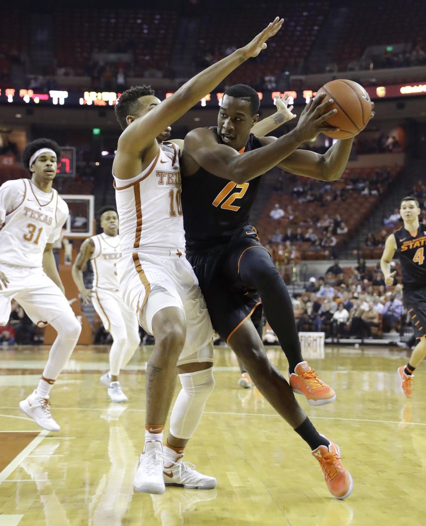 Oklahoma State forward Cameron McGriff (12) drives past Texas guard Eric Davis Jr. (10) during the first half of an NCAA college basketball game, Wednesday, Jan. 4, 2017, in Austin, Texas. (AP Photo/Eric Gay)
