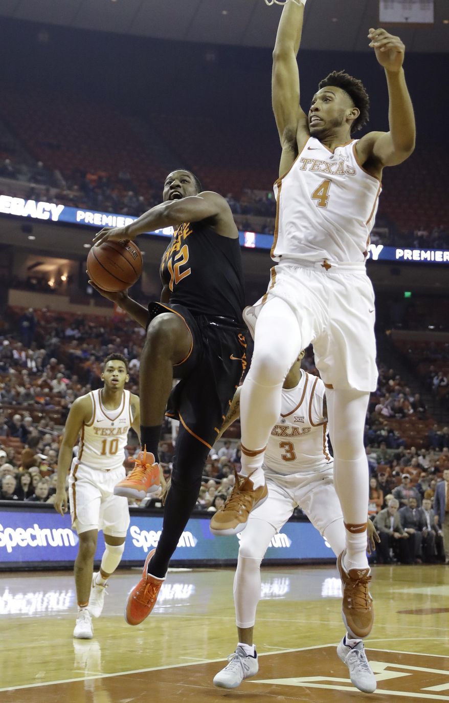 Oklahoma State forward Cameron McGriff (12) drives to the basket against Texas center James Banks (4) during the first half of an NCAA college basketball game, Wednesday, Jan. 4, 2017, in Austin, Texas. (AP Photo/Eric Gay)