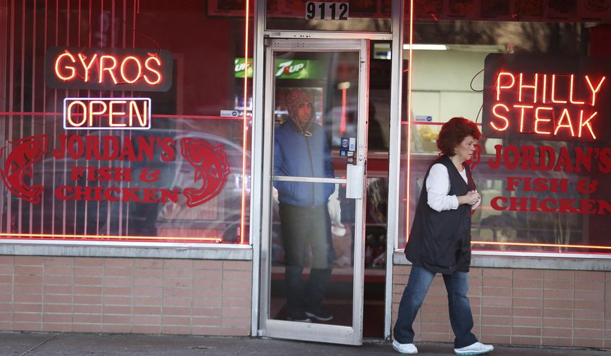 A woman leaves Jordan's Fish and Chicken following a fatal early morning shooting Wednesday, Jan. 4, 2017. Indianapolis police said multiple men had been found fatally shot inside the restaurant following what a co-owner said is an apparent robbery. (Kelly Wilkinson/The Indianapolis Star via AP)